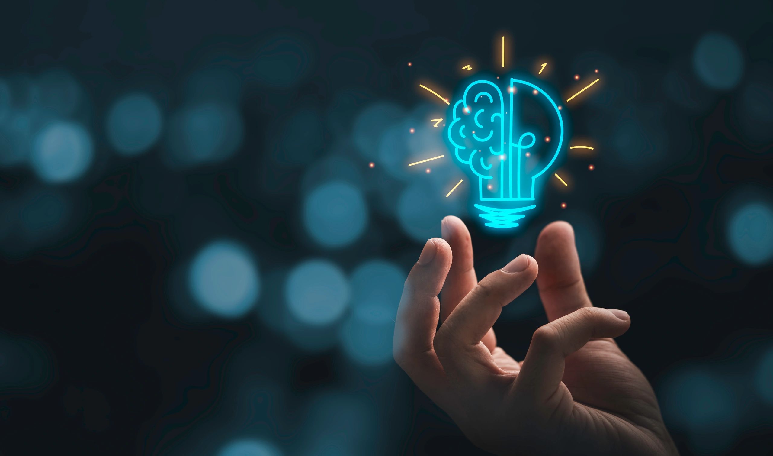 Hand holding drawing virtual lightbulb with brain on